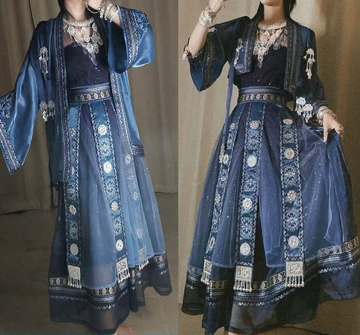 two images of a person wearing a dark blue outfit are placed sidebyside. the outfit consists of a dark blue dress with a decorative belt, a kimonostyle jacket, and ornate jewelry. the dress features decorative strips of fabric, with geometric patterns and circular elements, running vertically down the skirt, with a sheer overlay. the first image shows the outfit with a long, light blue, openfront jacket. the second image shows the outfit with a shorter, cropped jacket, which has slightly darker shades of blue. the jewelry includes a necklace with a silver pendant and multiple bracelets worn on the wrists. the person is standing with their arms slightly raised and hands angled. the background of the images is a neutral beige color.