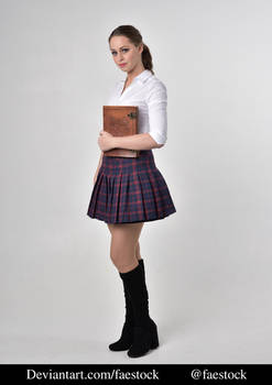 a fullbody studio shot of a young woman dressed in a school uniform. she's wearing a white blouse, a red and navy plaid pleated skirt, and black high boots. she's holding a brown book or journal in her hands and looking at the camera with a serious expression. the background is a plain grey.