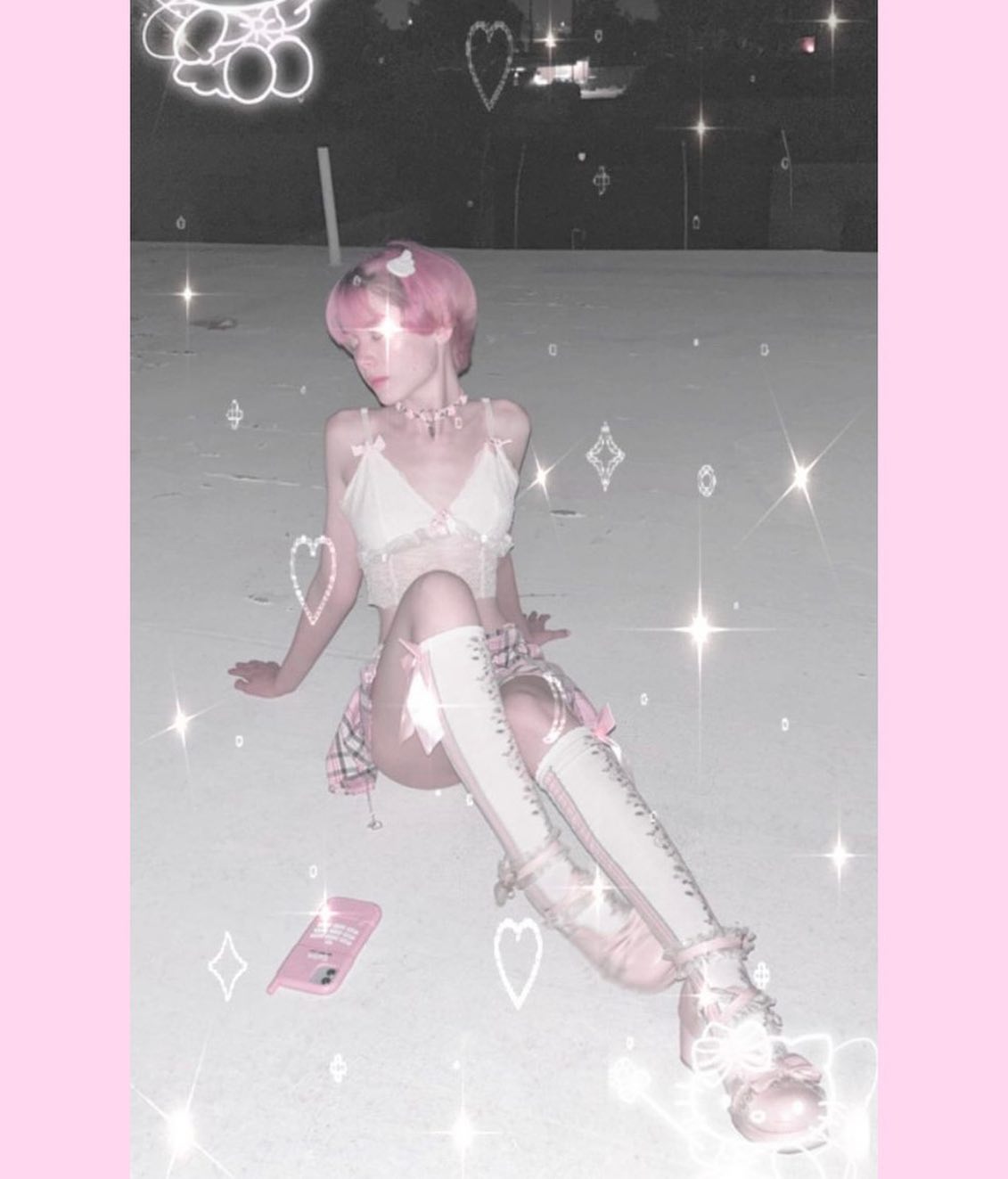 the image depicts a young woman with short pink hair wearing a pastel pink and white lingerieinspired outfit.  she's sitting on a rooftop at night, dressed in a delicate lace camisole, a short pleated skirt, kneehigh socks with bows, and ornate mary janestyle shoes. the overall aesthetic is very "kawaii" and dreamy, enhanced by a heavy use of pink filters and glitter effects applied digitally.  a pink cellphone lies on the ground near her.  the background is blurred but shows the nighttime sky. the style evokes a blend of y2k, lolita, and soft grunge aesthetics.