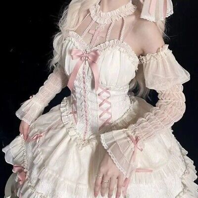 a closeup photo of a woman wearing an elaborate offtheshoulder white and pink sweet lolita dress. the dress features a laceup corset bodice, sheer sleeves, and multiple layers of ruffles and bows. the woman is posing with her hands on her skirt, showcasing the intricate details of the garment.