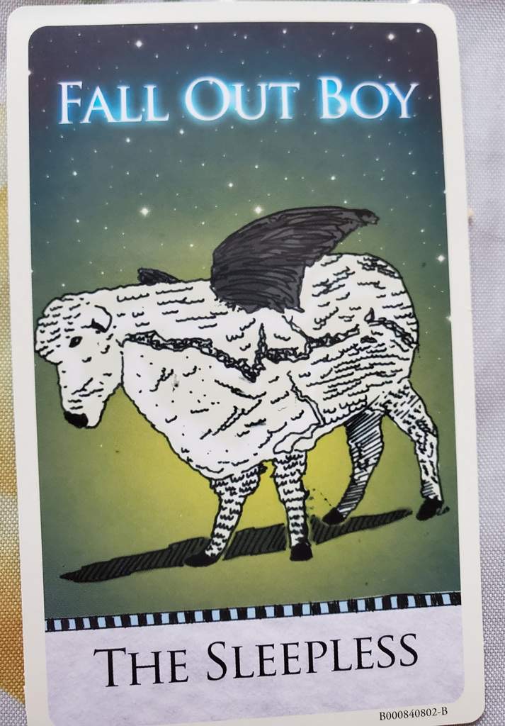 this is an album art card for fall out boy's album "the sleepless". the card features an illustration of a winged sheep against a background of stars. the sheep is white with black detailing and has a large, black wing. the card is edged with a black and white striped border and includes the band's name and album title. the bottom right corner includes the album's barcode.
