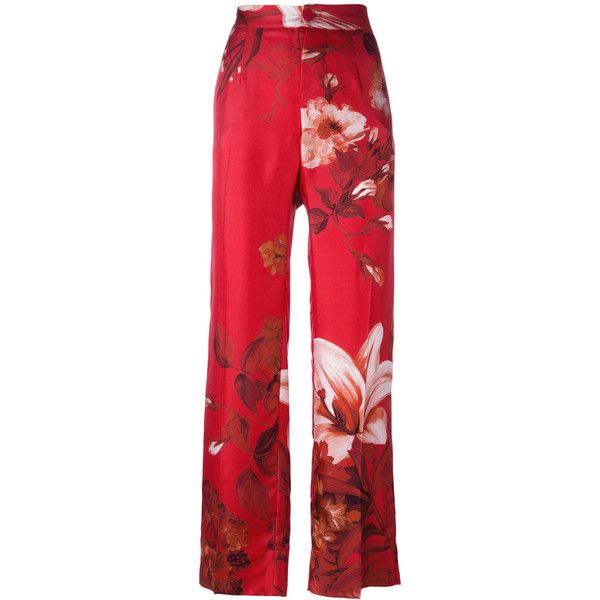 a pair of women's red wideleg trousers with a floral print. the pants are highwaisted and appear to be made of a silk or satinlike material. the floral print features large lilies and other flowers in shades of brown, white, and red against a vibrant red background. the trousers are shown on a white background.