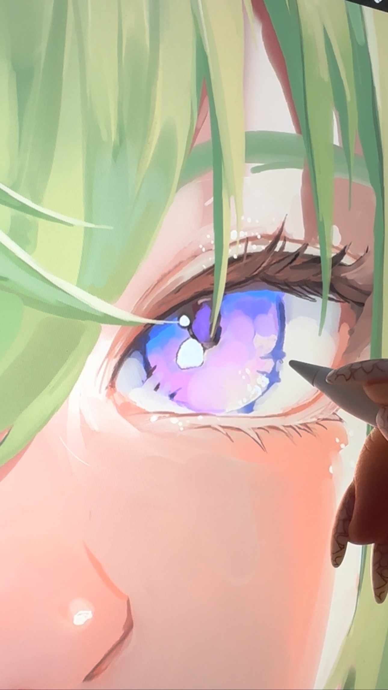 the image is a closeup shot of a digital painting in progress.  the focus is on a highly detailed animestyle eye with vibrant purple and blue hues.  the character's light green hair is visible in the upper part of the frame.  a hand holding a stylus is partially visible, indicating the digital painting process. the style is soft, with pastel tones and a focus on smooth blending of colors. the overall impression is one of beautiful, delicate artistry.