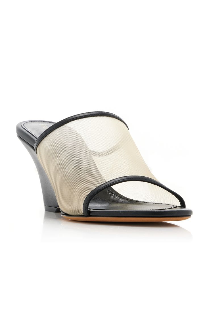 a pair of women's beige mesh wedge sandals with black leather trim are shown on a white background. the sandals are opentoed and have a slightly pointed toe. the wedge heel is visible. the sandals are positioned at a slight angle.