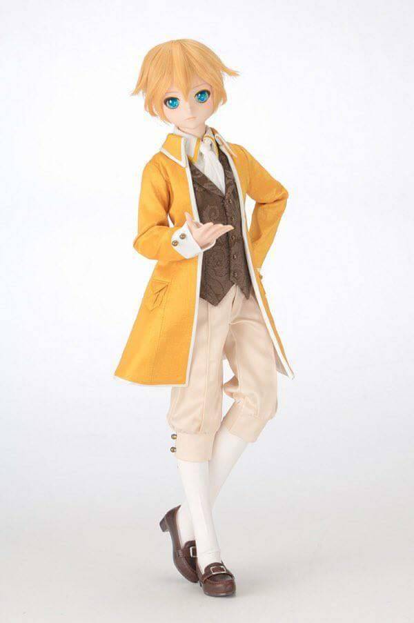 a balljointed doll, likely a dollfie by volks, is posed against a white background. the doll is dressed in a yellow frock coat, a brown patterned vest, white breeches, and brown buckled shoes. it has short blonde hair and vibrant blue eyes. the doll is standing with one leg slightly forward and one hand gesturing. the image is welllit, likely with studio lighting, and the perspective is at eye level with the doll.