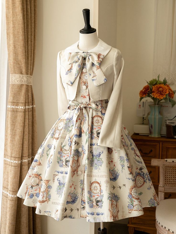 a creamcolored lolita fashion dress is displayed on a mannequin. the dress features a whimsical print of clocks, birds, and flowers.  it has a square neckline and a full skirt that falls to knee length.  a matching bolero jacket with a large collar is worn over the dress. the background is a creamcolored wall with sheer curtains. a vase of flowers sits on a table to the right.