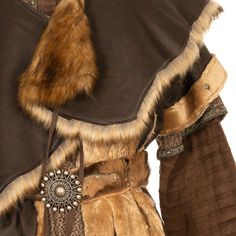 a closeup of a brown furtrimmed medievalstyle cloak, dress, and belt.