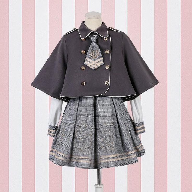a gray lolita fashion dress with a cape. the dress has a pleated skirt and a doublebreasted cape with gold buttons. the dress is styled with a white shirt and a gray and gold tie.