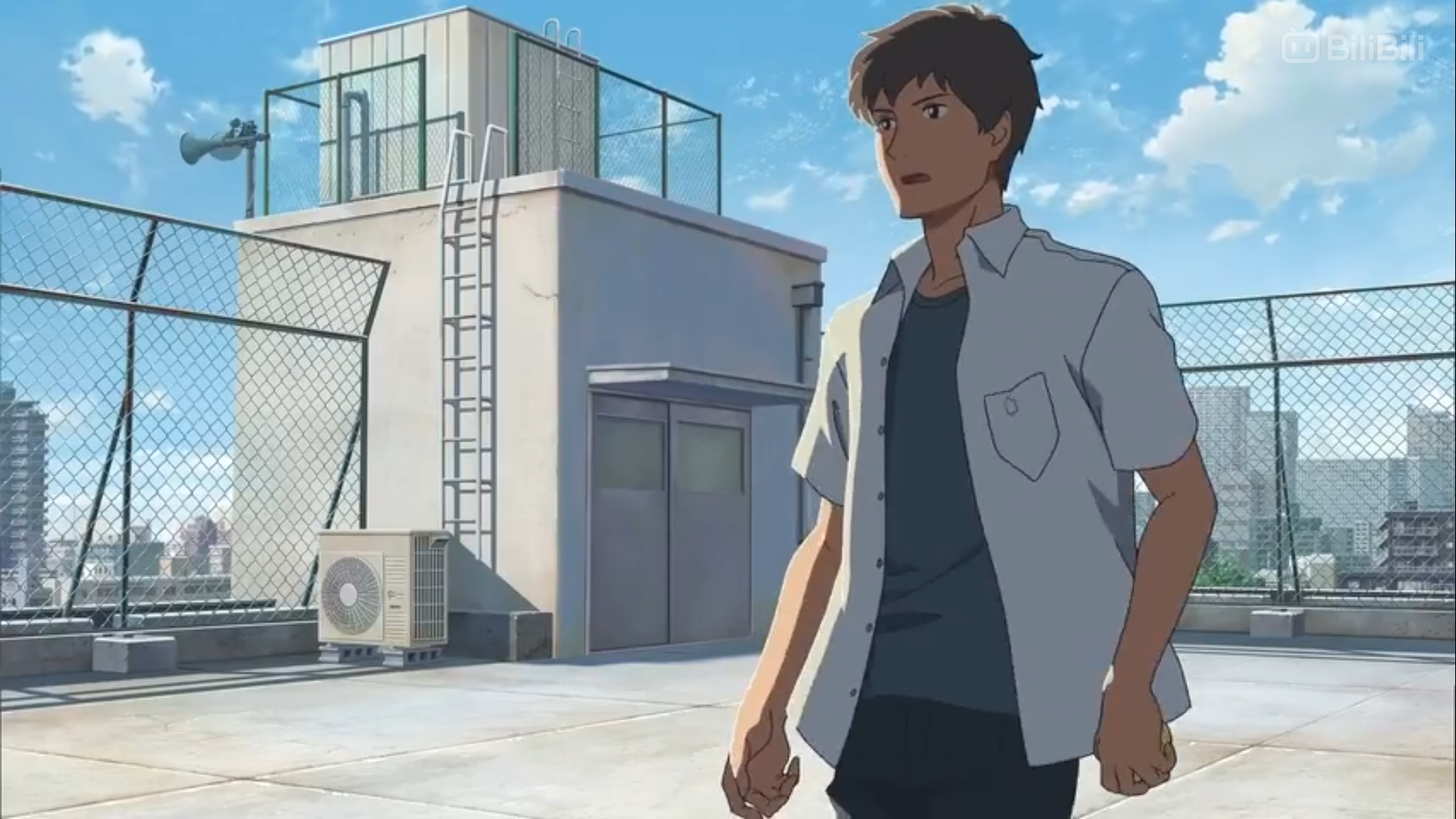 the image is a still from an animated film. it shows a young man with brown hair and a determined expression standing on a rooftop in the daytime. he is wearing a light blue, shortsleeved, buttondown shirt and dark pants. the rooftop is surrounded by a chainlink fence, and there are buildings and a blue sky with some clouds in the background. the scene is brightly lit by natural sunlight. the overall color palette is light and airy, with blues, grays, and greens dominating.