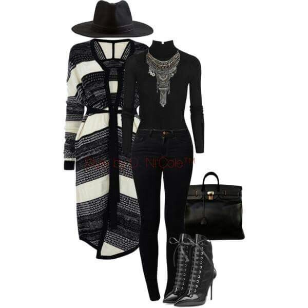 a woman is dressed in a black and white sweater cardigan, black skinny jeans, black boots, and a black handbag. she is also wearing a black hat and a silver necklace. she looks very fashionable and stylish.