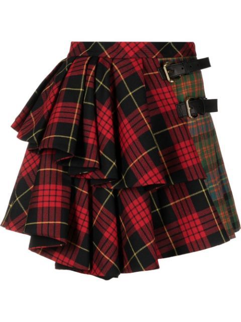 a short, asymmetrical kiltstyle skirt featuring a red, black, and yellow tartan pattern on one side and a green, red, and yellow tartan pattern on the other, fastened with two black leather buckles. the skirt has a layered, pleated design.