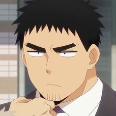 this is a portrait of an adult anime man with short dark hair and stubble. he appears to be wearing a suit, and the top of a white dress shirt is visible under his jacket. he has a stern expression on his face and dark, thick eyebrows. the image is a closeup, focusing on his face and upper chest. the background is blurry and suggests an indoor setting. the lighting appears to be artificial, likely indoor lighting.