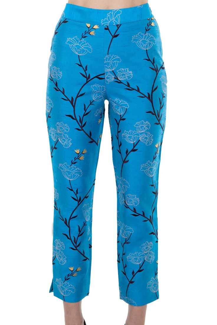 a pair of women's blue floral pants are shown in a closeup photo. the highwaisted pants have a wide leg and are cropped, making them an elegant and modern choice.
