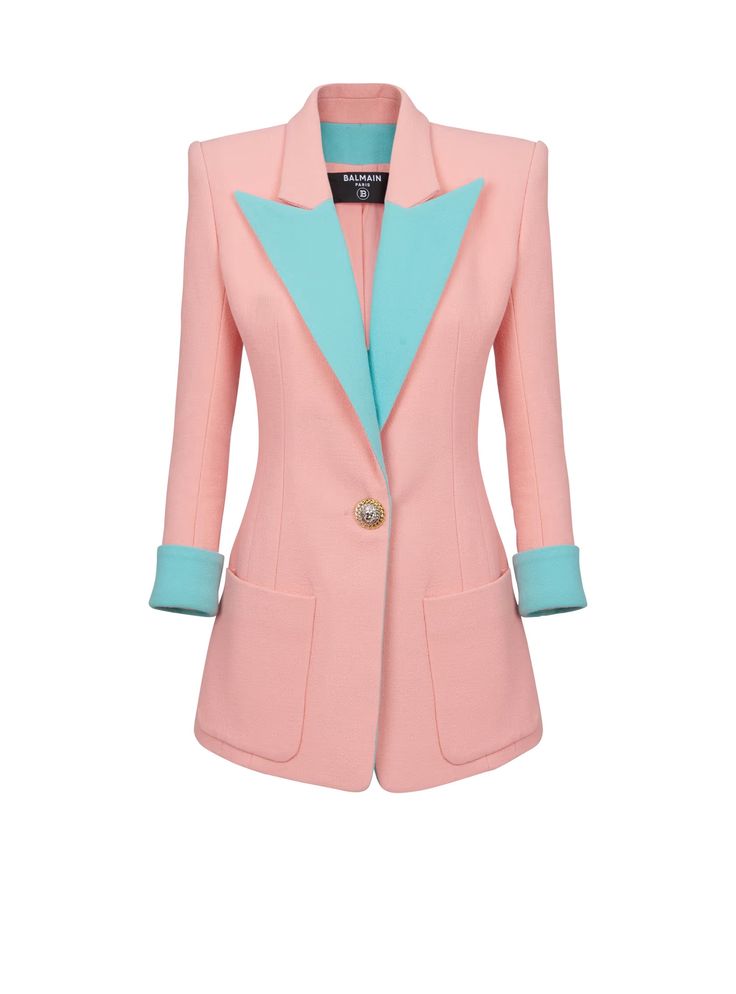 a pink balmain blazer with blue accents is displayed on a white background. the blazer has long sleeves, two pockets, and a blue collar and cuffs. the blazer is buttoned in the middle with a gold button.