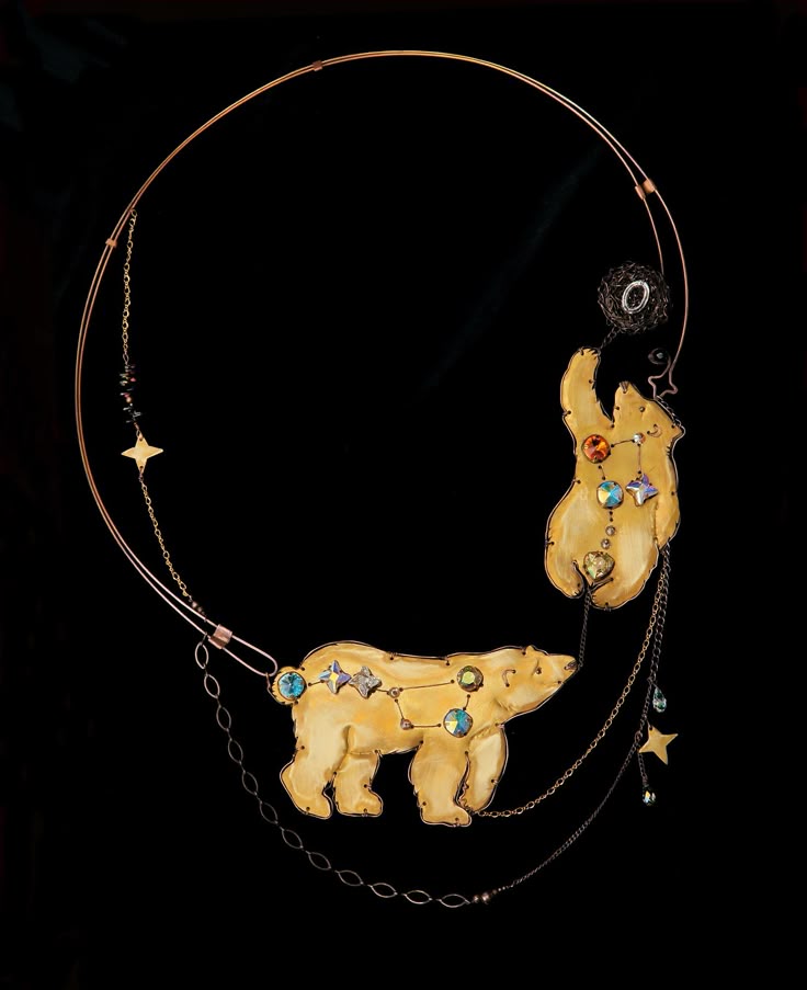 a detailed and artistic necklace featuring a circular gold frame. attached to the frame are two stylized polar bear pendants with constellation patterns adorned with colorful jewels. chains and other decorative elements hang from the bears and the frame. the background is black, highlighting the intricate details of the necklace.