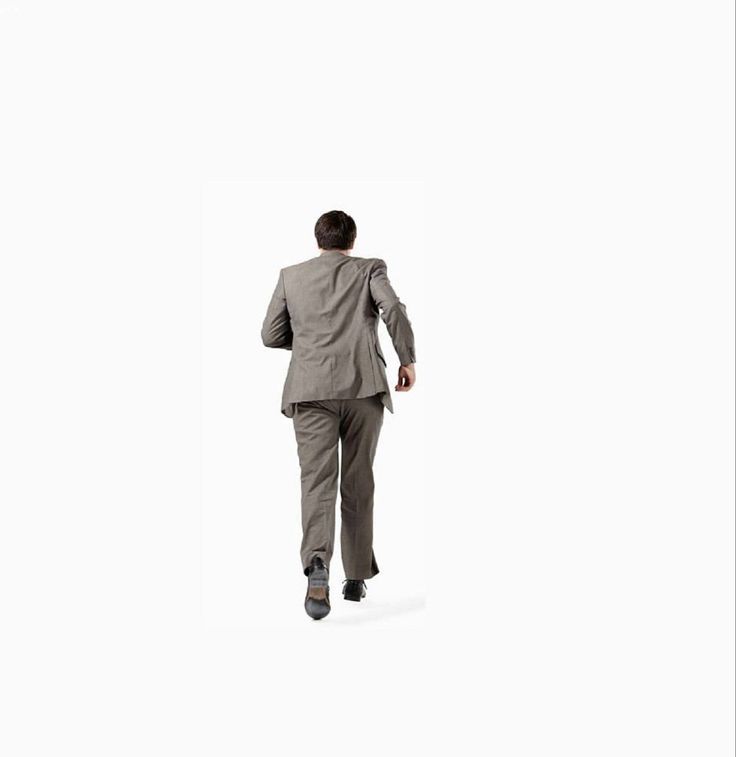 a man in a gray suit is running away from the camera. the background is white. he is looking straight ahead.  the image is isolated, showing only the man.