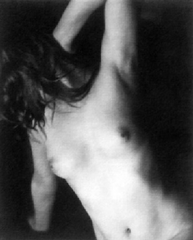 the image is a black and white photograph of a nude woman's torso. she is positioned in a threequarter view, her arm raised above her head, her hair cascading down her back. the lighting is dramatic, creating strong contrasts between light and shadow, emphasizing the curves of her body. the overall mood is sensual and intimate, with an artistic approach to capturing the female form.