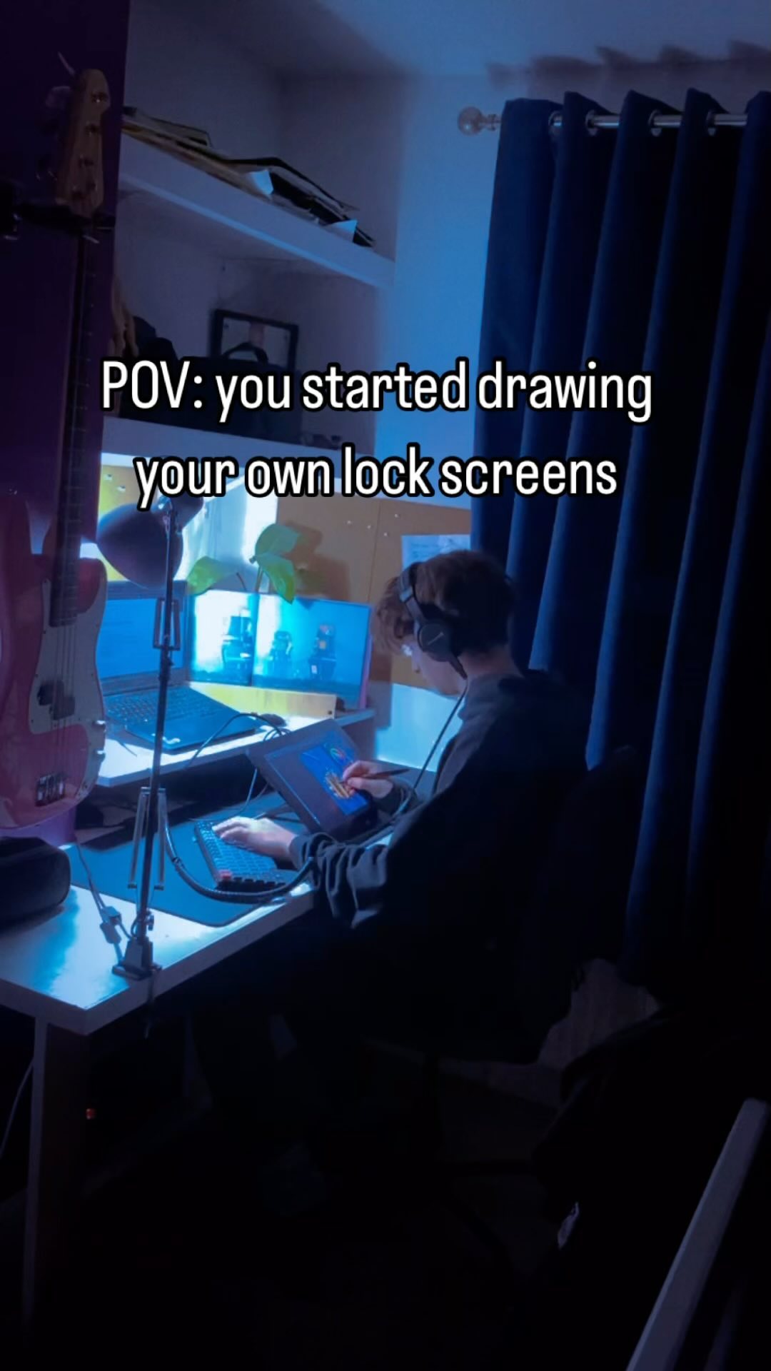the image is a pov shot of a person sitting at their computer and drawing on a tablet. they are creating their own lock screens. the room is dark, lit only by the blue light of the computer screens. there is a guitar in the corner and dark blue curtains behind the person. the overall ambiance is dark and moody, emphasizing the focus on the creative process. the text overlay emphasizes the pov aspect of the image, suggesting a relatable experience for viewers who also create their own digital content.