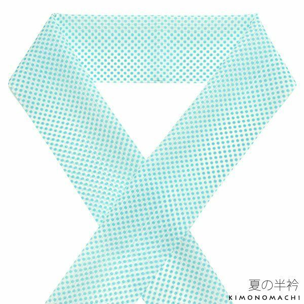 a light blue scarf with a polka dot pattern is arranged in a knotlike shape, with part of the scarf forming a triangular opening in the center. at the bottom right, there is japanese text with "kimonomachi" written in english below it.