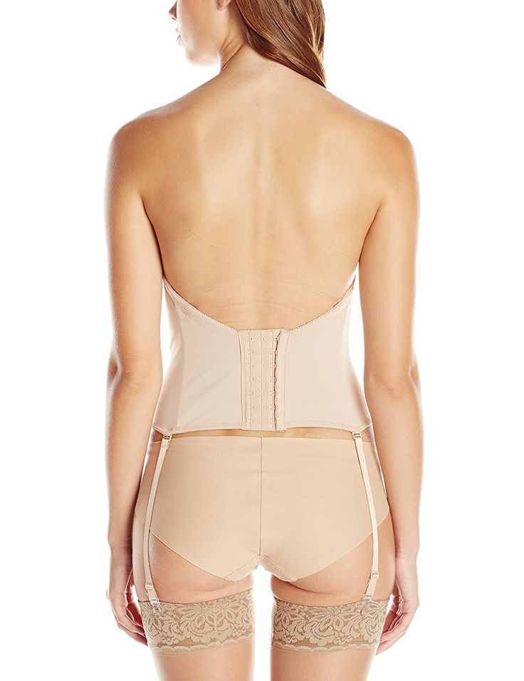 a woman is seen from the back, wearing beige lingerie, including a strapless corset, a garter belt, and stockings.
