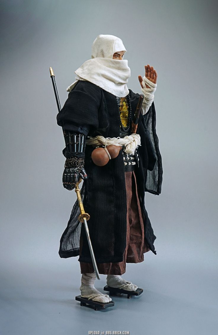 a closeup shot of a samurai action figure, showcasing intricate details and accessories. the figure is dressed in traditional samurai attire, complete with a black robe, white hood, and intricate armor. it holds a katana and appears to be ready for battle. the figure stands against a gray background, creating a sense of depth and highlighting the figure's details.