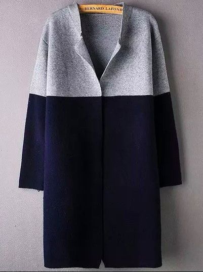 a long, color block cardigan or sweater coat is hanging on a wooden hanger. the coat has long sleeves and is knitted. the top portion of the coat is gray, while the bottom part is navy. the hanger is labeled with the brand name "bernard lafond". the background is a plain gray wall.