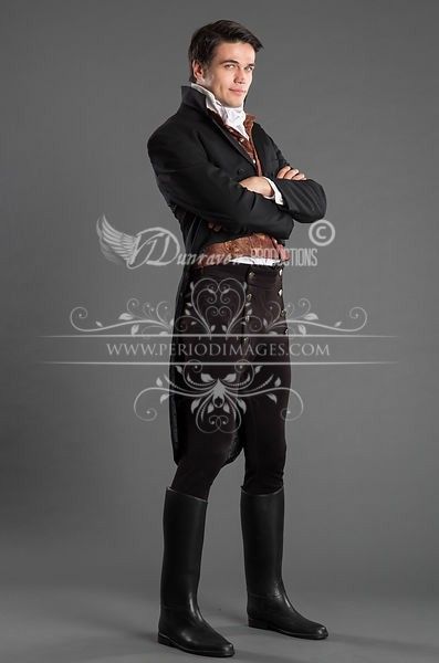 a man stands in a studio setting wearing a period costume. he is dressed in a black coat, waistcoat, trousers, and tall black riding boots. the costume appears to be from the 18th or 19th century. he has his arms crossed and is looking at the camera. the background is a plain gray color. watermarks from "dunraven productions" and "period images" are visible on the image.