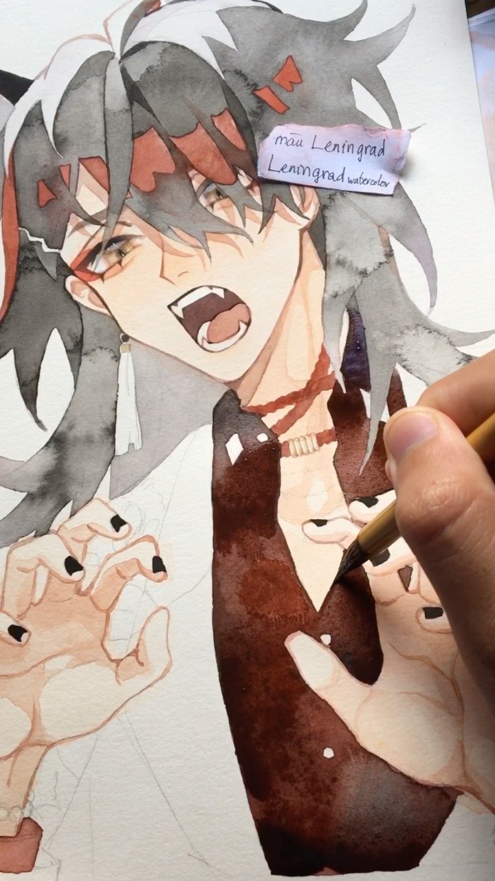 the image shows a closeup of a watercolor painting in progress. the artwork depicts a stylized animestyle male character with long, dark hair streaked with red highlights. he has a sharp, intense facial expression with his mouth open in a sort of shout or yell. the character is wearing a white jacket or shirt over a dark brown or burgundy inner garment. his hands are visible, with dark fingernails.  a hand is shown in the process of painting the character’s clothing using a paintbrush and watercolors.  a small note in the upper right corner credits the artist as "mau leningrad" and "leningrad watercolors".  the overall style is expressive, with a focus on capturing emotion through the character's expression and the use of color.