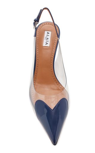 a pair of blue and clear heeled pumps. the heels are pointed toe and feature a heart shape design. the shoes are made by alaia and are slingback style.