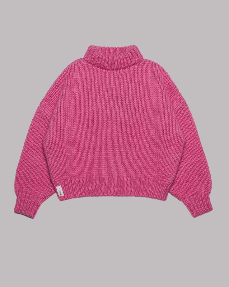 a pink knitted turtleneck sweater with long sleeves. the sweater is a relaxed fit and has a slightly oversized look. it is a cozy and comfortable piece of clothing that is perfect for winter.