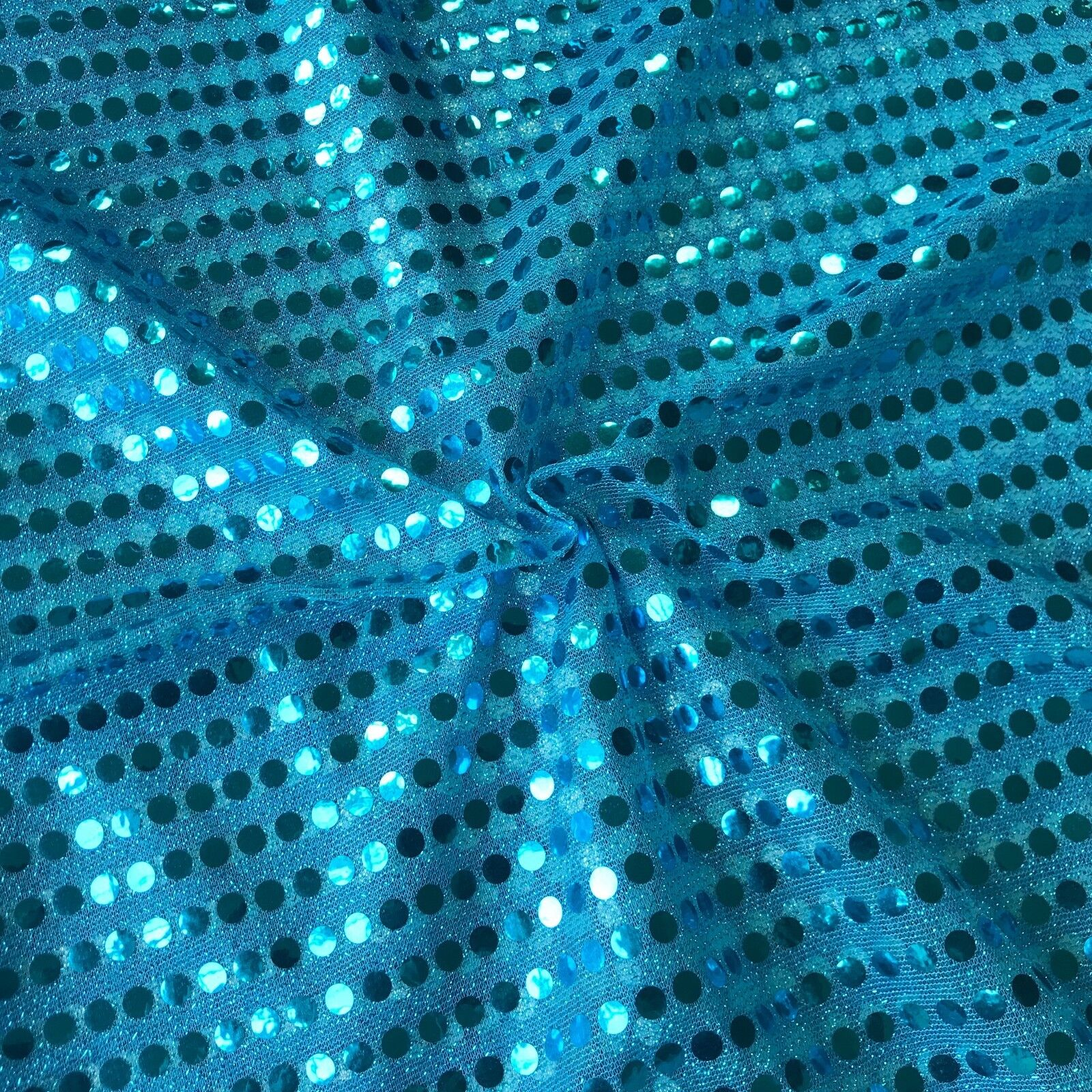 the image showcases a vibrant blue fabric adorned with shimmering sequins. the sequins are arranged in a repeating pattern, creating a dazzling visual effect. the closeup perspective highlights the intricate details of the fabric's texture and the captivating sparkle of the sequins.