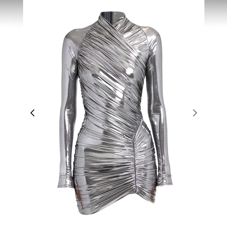 a silver, metallic mini dress with long sleeves and a high neck. the dress is ruched on one side and has a wrap detail on the front.