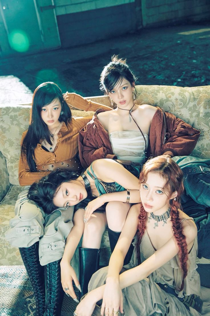 the image shows four women from the kpop girl group aespa.  they are wearing outfits that evoke a steampunk aesthetic with leather straps, corsets, and boots. they are posing on a vintagestyle couch, giving off a powerful and charismatic vibe.  the setting is industrial with exposed brick and metal, creating a gritty backdrop that contrasts with their feminine beauty.  the image utilizes artificial lighting, which gives it a dramatic, almost cinematic quality.