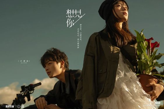 a movie poster featuring a young man and woman. the man is sitting on a motorcycle, while the woman is standing beside him, holding a potted red calla lily. the sky is cloudy, and the overall tone of the poster is romantic and melancholic. the chinese text on the poster suggests a story about youth and love.