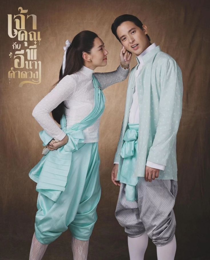 a man and a woman wearing traditional thai clothing