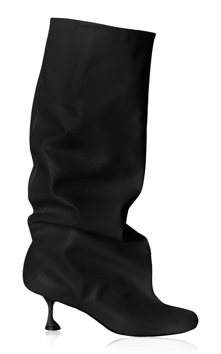 the image shows a pair of women's black leather slouch boots with a kitten heel.  the boots are made of a soft, pliable leather that drapes loosely around the leg.  they have a simple, elegant design and are presented on a white background.