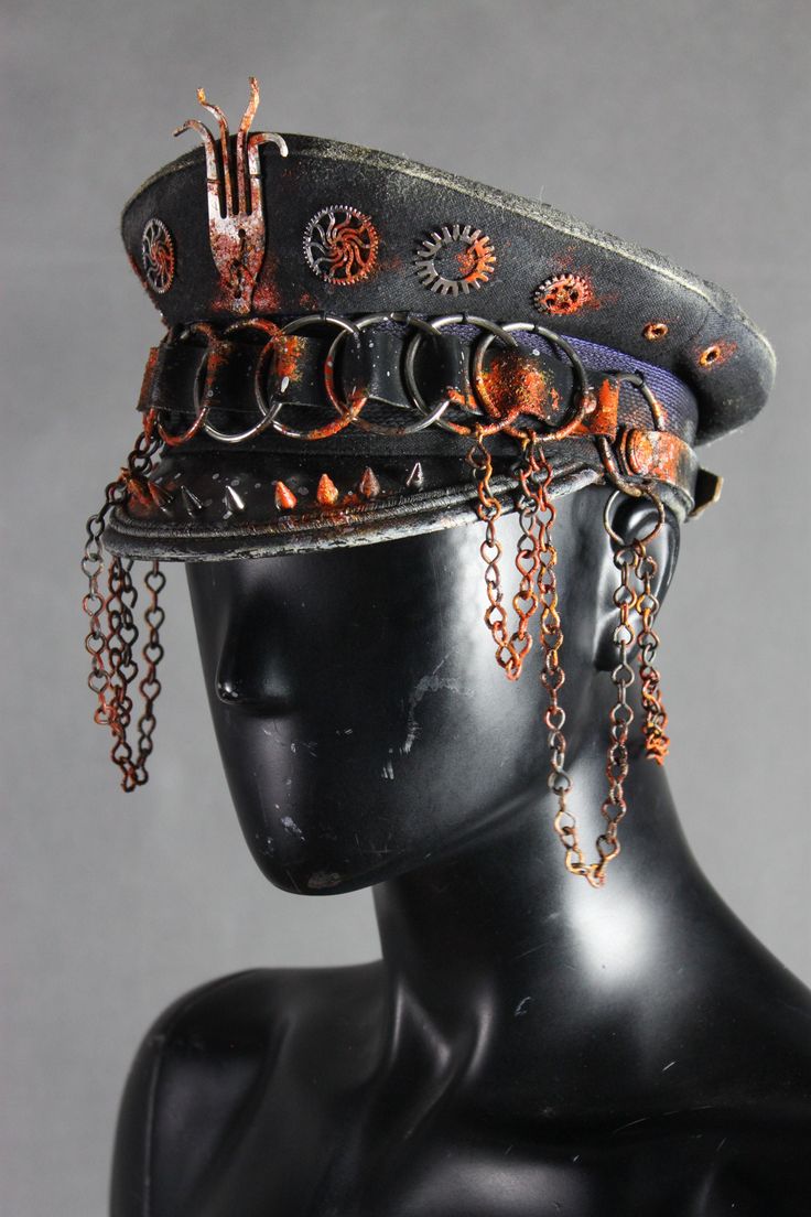 a steampunkstyle hat, with gear accents, chain details and a rusty patina. it's perched on a black mannequin head, and the hat has multiple chains hanging from it.