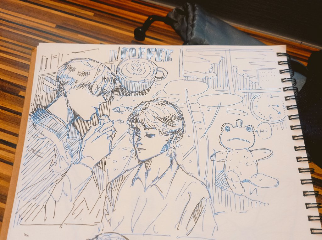 this is a sketch of two male characters in a cafe setting. the one on the left is sitting, while the one on the right is slightly behind and facing the left side. they are both drawn in a manga style. the background of the sketch includes a cup of coffee, a frog teddy bear, and a clock. the sketch is drawn in blue and black pen on a white piece of paper. the paper is part of a bound notebook with a spiral binding.  the sketch is done in a style that is reminiscent of manga, with its exaggerated features and expressive lines.