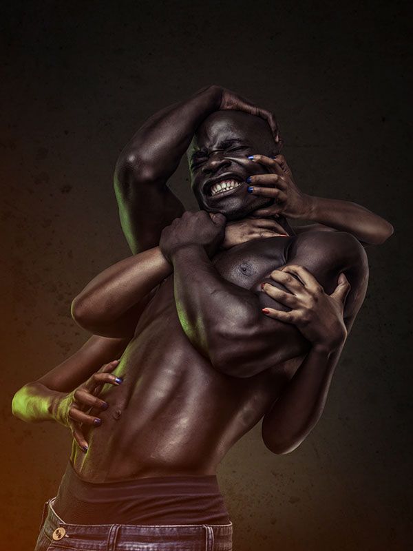 a shirtless muscular man is held in a powerful pose by a