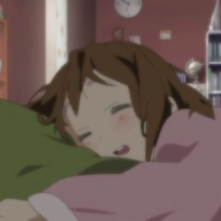 a young anime girl with long brown hair is sleeping on a pillow, she is wearing a pink shirt and looks very cozy.