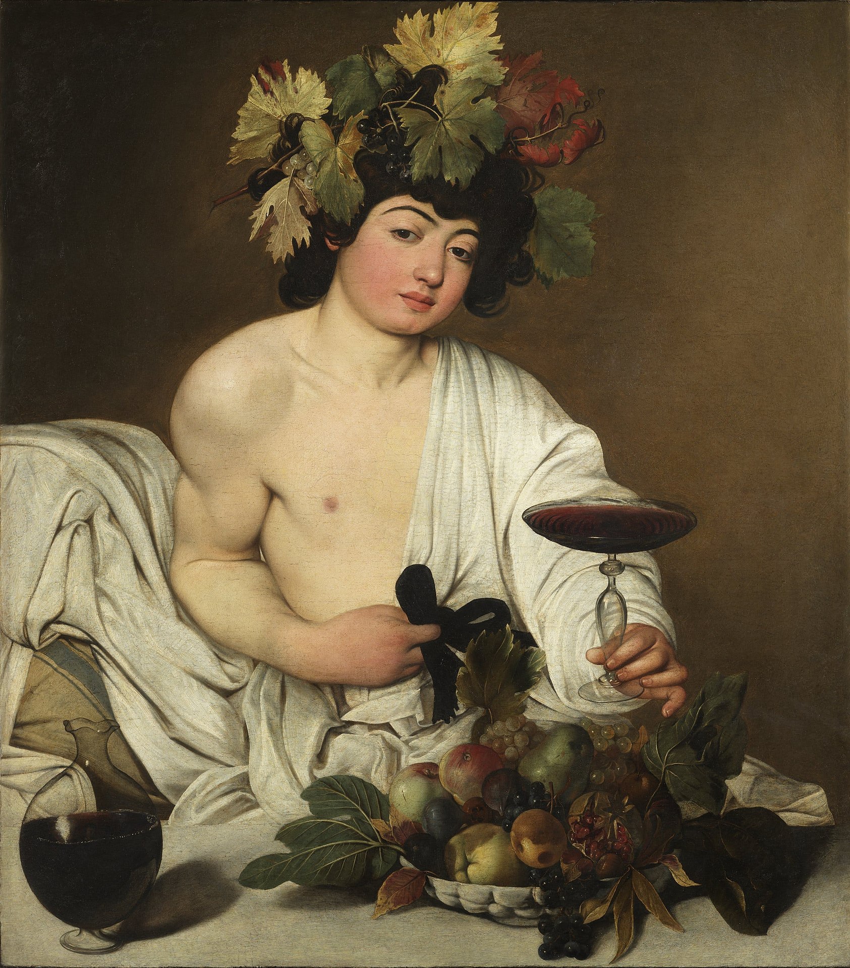 the image is a baroque painting of bacchus, the roman god of wine, depicted as a youthful and androgynous figure. he is adorned with a crown of vine leaves and grapes, symbolizing his association with winemaking and revelry. bacchus is seminude, draped in a white cloth, and holds a stemmed glass of red wine in his right hand. his left hand rests on a black ribbon, which may be part of his attire. a table in front of him displays a lavish spread of fruits, including grapes, apples, pears, and pomegranates, further emphasizing the theme of abundance and pleasure. a glass decanter filled with red wine sits beside the fruit, hinting at the continuous flow of wine. the background is a dark, undefined space, which focuses the viewer's attention on the illuminated figure of bacchus and the richness of the still life.