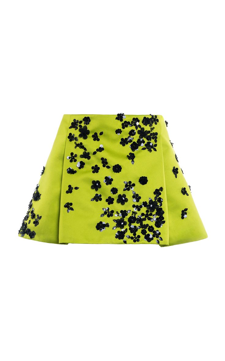 a green mini skirt with black sequins in a floral pattern.