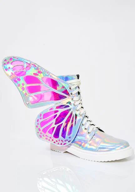 the image shows a pair of white combat boots with large, iridescent butterfly wings attached to the sides. the wings are holographic, displaying shades of pink, purple, and silver. the boots themselves are a shiny, iridescent material and have white laces.  the overall style is whimsical and fantastical, incorporating elements of fairycore and pastel goth aesthetics. the boots are shown against a white background.