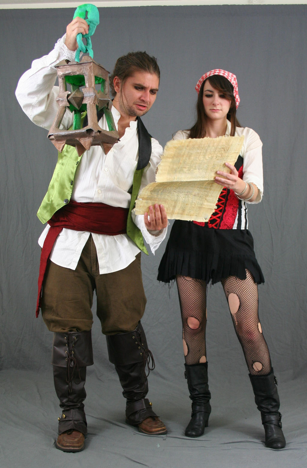 a fullbody shot of a man and a woman dressed in pirate costumes, posed against a gray background. the man, on the left, is wearing a white shirt, a green waistcoat, brown breeches, and tall brown boots. he holds a large, ornate lantern. the woman, on the right, wears a red and white bandana, a black skirt, ripped fishnet stockings, black boots, and a red corset under her white shirt. she's holding a rolledup piece of parchment, which looks like a treasure map. they appear to be roleplaying as pirates. the image has a fantasy and historical feel.