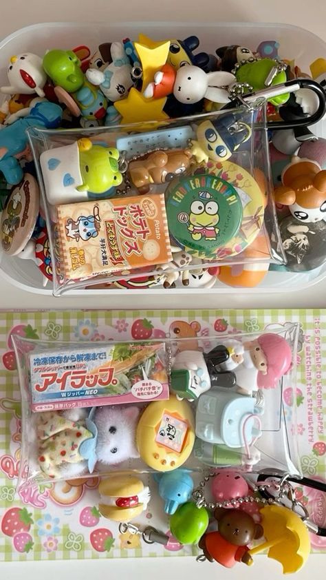 the image shows two clear containers filled with kawaii toys and trinkets. the top container contains a variety of items including candy boxes, keychains, and other small toys. the bottom container features similar items, including a small package labeled "アイラップ。" and more keychains. the items appear to be arranged haphazardly, giving the impression of a collection of fun, colorful objects.