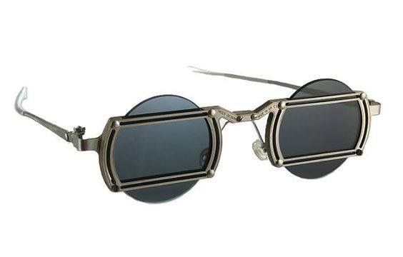 the image shows a pair of steampunkstyle sunglasses with round, darktinted lenses. the sunglasses have a detailed metal frame with a retro design. the overall aesthetic is a blend of vintage and industrial styles. the background is plain white.