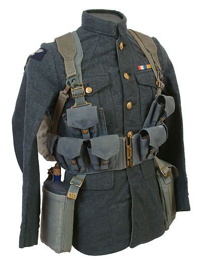 a closeup of a british soldier's uniform from world war i. the uniform is a dark blue tunic with a variety of straps and pouches attached. the soldier is wearing a belt with a canteen and ammo pouches.