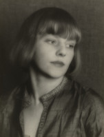 a black and white portrait of a young woman with a bob haircut and bangs. she is wearing a darkcolored garment with a high collar. the image is softly focused, giving it a timeless and elegant feel. the woman's expression is pensive and serious. the overall style of the portrait is reminiscent of the 1920s or 1930s.