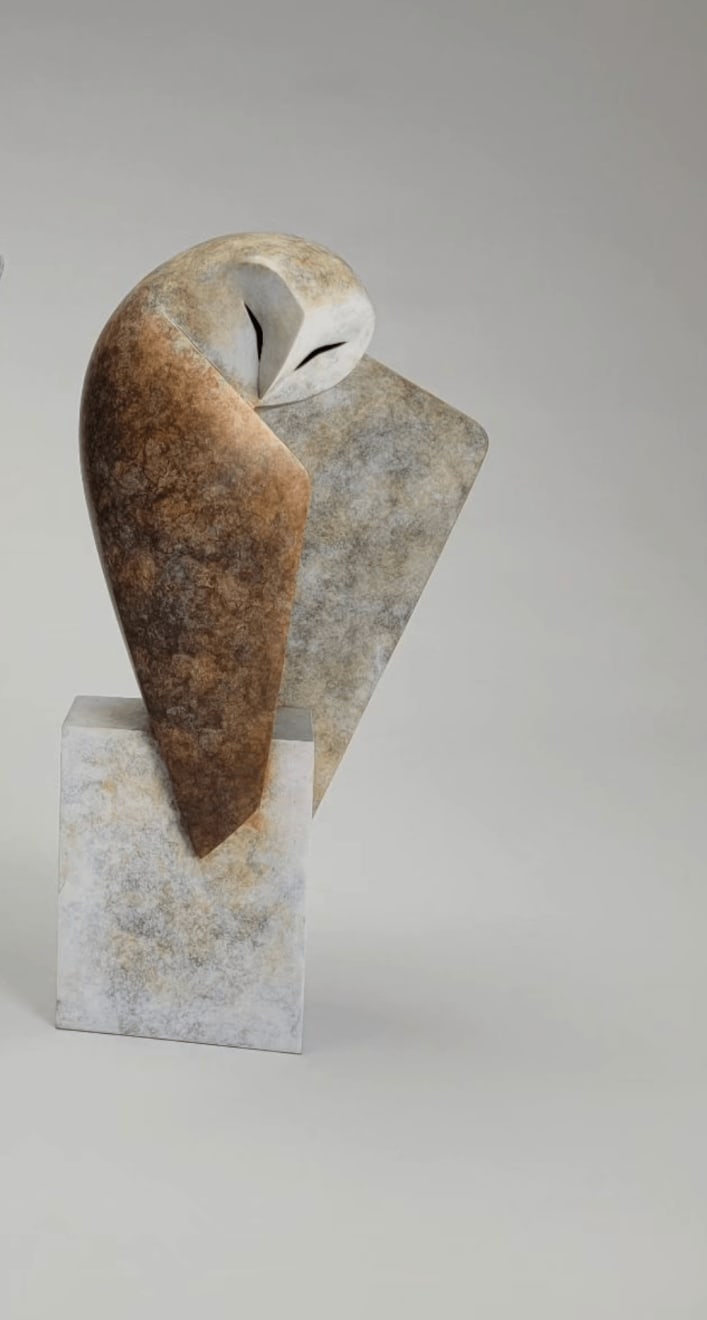 a sculpture of an owl, crafted from marble or a similar material, with a modern and abstract design. the sculpture depicts the owl in a graceful, stylized form.