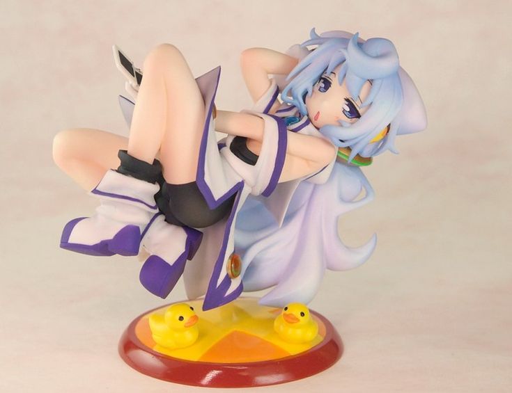 the image shows a closeup view of a collectible anime figurine.  the figurine depicts a young girl with long, lightpurple hair, dressed in a casual outfit featuring shades of white and purple. she's in a playful, slightly reclining pose with her legs bent.  the base of the figurine features a yellow and orange design with two small yellow rubber ducks. the overall style is cute and expressive ("moe" or "kawaii"). the figurine appears to be made of pvc.  the background is a simple, lightcolored surface.